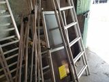 de nombreuses échelles appuyées contre un mur dans un garage