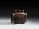 un vase marron posé sur une table blanche, près d'un mur noir