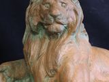 a statue of a lion that is laying down on the ground