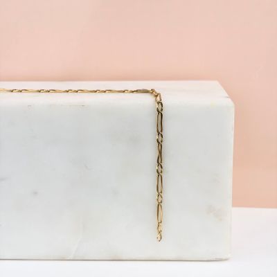 une boîte en marbre blanc à laquelle est suspendue une chaîne en or