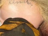 a woman with a tattoo on her neck with writing on it