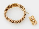 un gros plan d'un bracelet et d'une bague posés sur une surface blanche