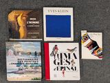 Plusieurs livres sont disposés sur une surface recouverte de moquette