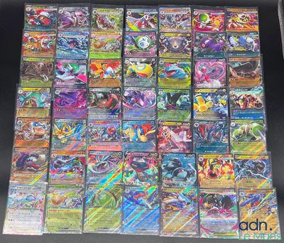 Les cartes Pokémon sont empilées les unes sur les autres sur une table.
