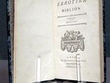 un livre ouvert posé sur une table, avec une bougie dessus