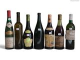 several bottles of wine are lined up in a row on a white surface