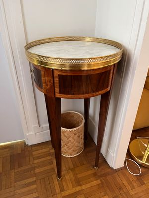 une petite table avec un plateau en marbre dans une pièce