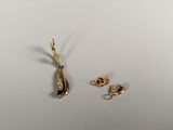 Deux bijoux sont posés sur une surface blanche.