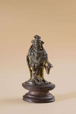bronze figurine of a woman holding a bird on a pedestal