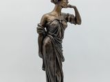 an image of a bronze statue of a woman holding a lamp