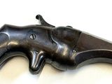 a gun that is laying on a white surface