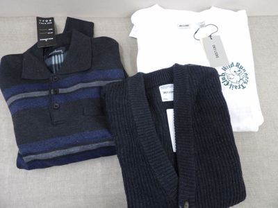 deux pulls et un gilet posés sur un canapé