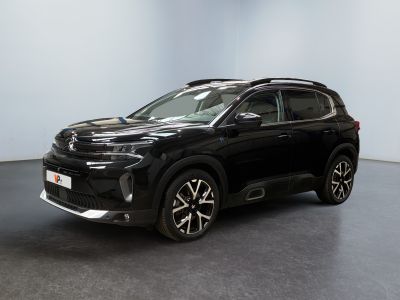 un SUV noir garé dans une pièce aux murs blancs