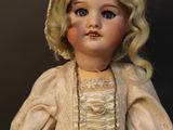 a close up of a doll wearing a dress and a hat