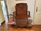 a chair and a dresser in a room with a painting on the wall