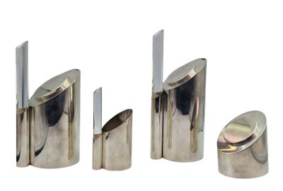 quatre pièces métalliques argentées sont disposées sur une surface blanche