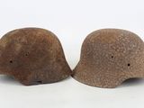 pair of old helmets on a white background