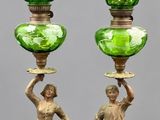 une paire de vases en verre vert reposant sur des socles en bois et ornés de figures