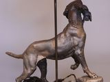 statue of a dog on a rock with a lamp on a table