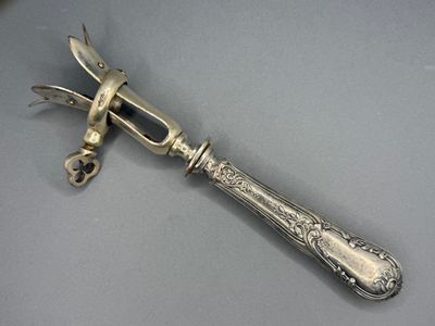 une cuillère en argent sur laquelle est posé un couteau, posée sur une table