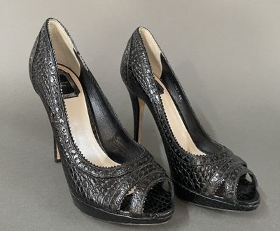 pair of women ' s black high heeled shoes on a gray surface