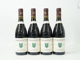 quatre bouteilles de vin sont alignées sur une surface blanche