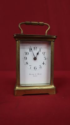 a small clock that is sitting on a red surface