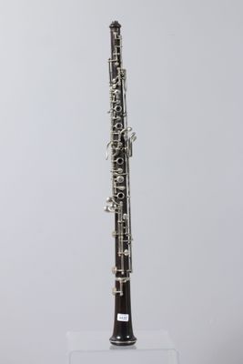 a close up of a clarinet on a clear stand against a white background