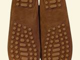pair of brown slippers with holes on them against a white background
