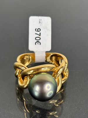 a close up of a ring with a black pearl on it