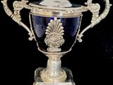 an antique silver plated trophy with a blue glass lid
