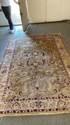 un homme debout à côté d'un tapis dans un garage