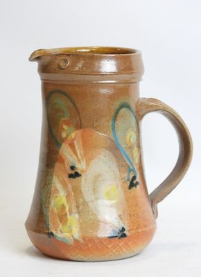 a brown pitcher with a horse on it on a white surface