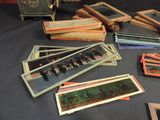 a lot of old photos on a table next to an old camera