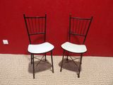 une paire de chaises pliantes noires et blanches adossées à un mur rouge