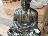 une statue de Bouddha assis sur une table en bois