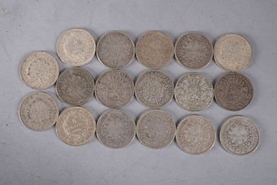 Plusieurs types de pièces de monnaie sont disposés en rangée sur une surface blanche