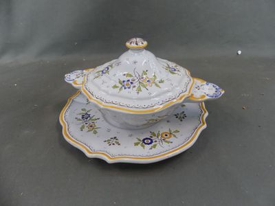 une image représentant une assiette blanche avec un couvercle à motifs floraux jaunes et bleus