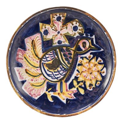 une assiette bleue et jaune décorée d'un oiseau et de fleurs