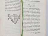 an open book with a green ribbon on it sitting on a table