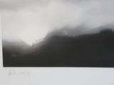 a black and white photo of a mountain with fog