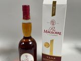 La bouteille de Maclote se trouve à côté d'un carton de vin.