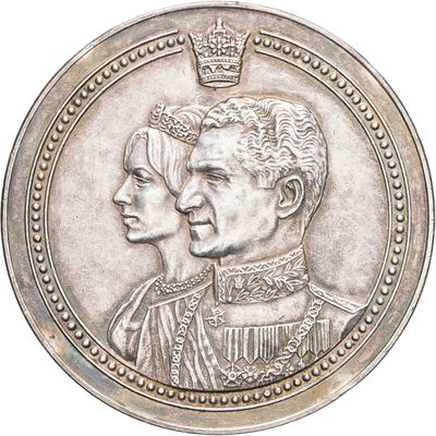 an image of a silver coin with a portrait of a man and a woman