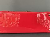 a close up of a red purse sitting on top of a table