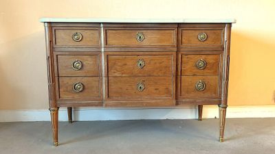 une commode ancienne avec un plateau en marbre et des poignées en laiton