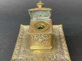 an antique brass inkwell on a tray with a lid