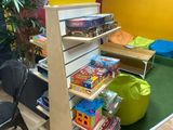 a bookshelf in the corner of a room with toys on it