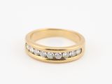 une bague en or jaune sertie de trois diamants sur fond blanc