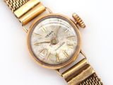 a close up of a gold wrist watch with roman numerals