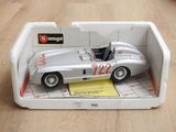 une petite voiture en argent dans une boîte blanche posée sur une table